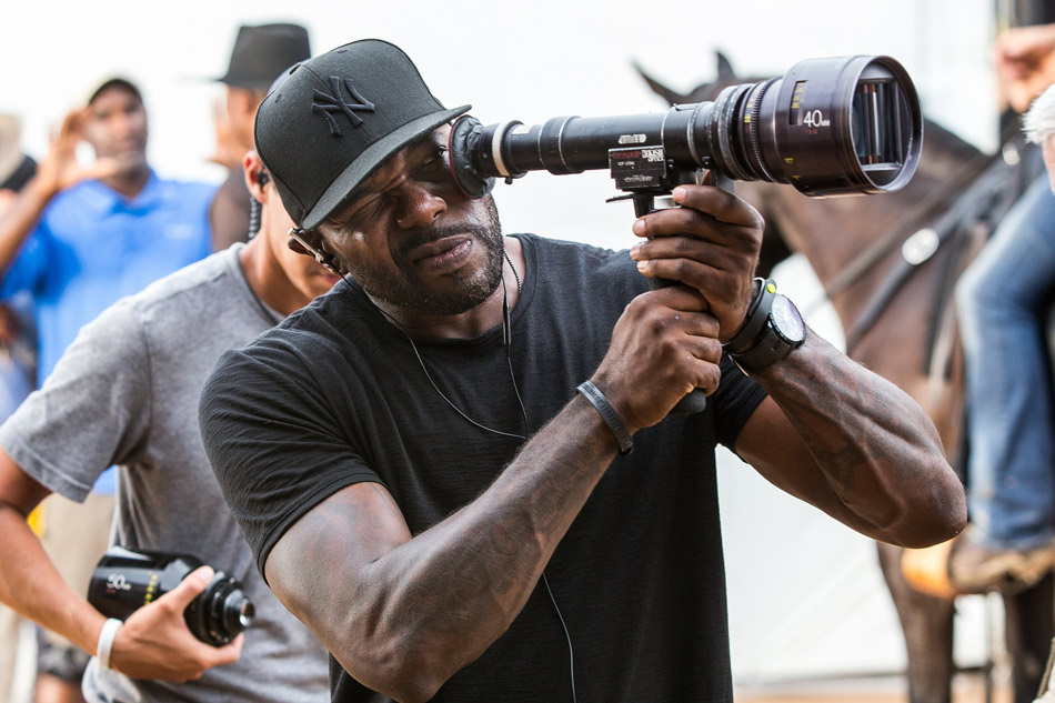 Director Antoine Fuqua looking into a Panavision Lens, behind the scenes of The Magnificent Seven.