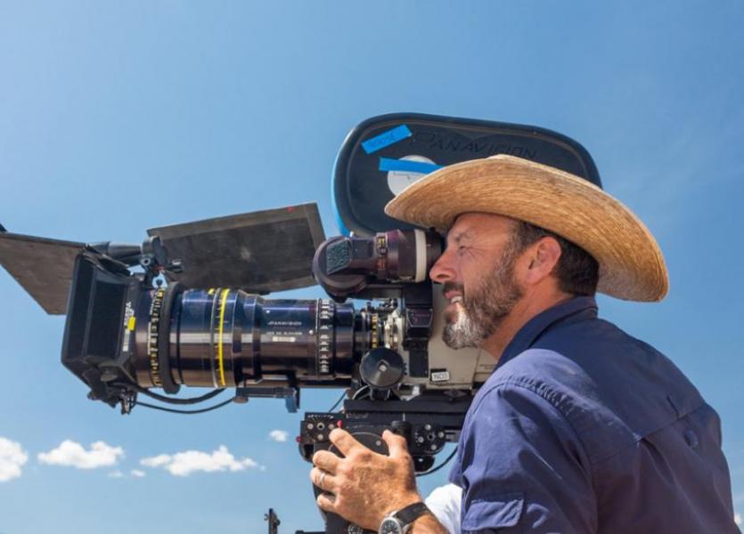 Cinematographer Mauro Fiore looking at a shot through a Panavision film camera.